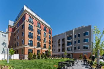 A courtyard with tables and chairs in front of an apartment building